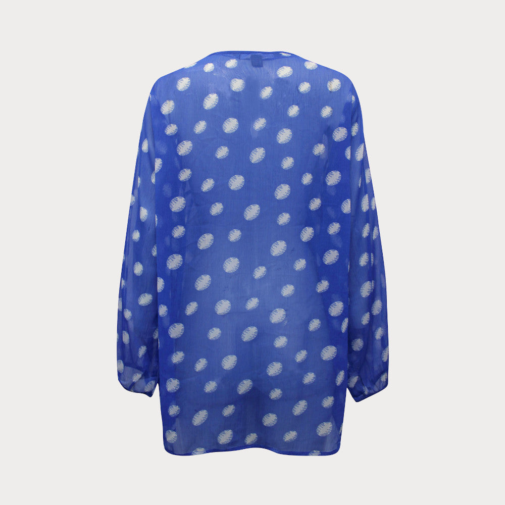 Bright blue and white spotty chiffon top with long sleeves and tie at the neck. 