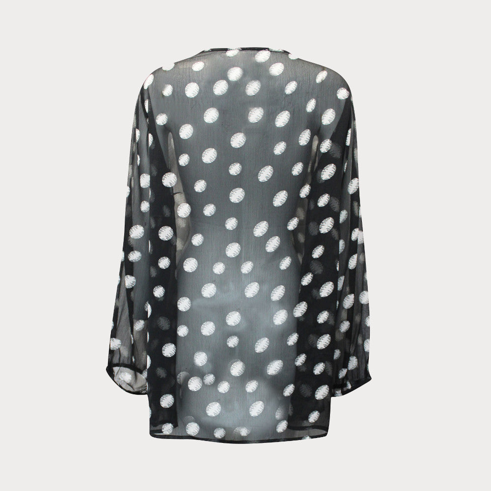 Black and white spotty top made of sheer chiffon with a tie detail at the neck and long sleeves. 