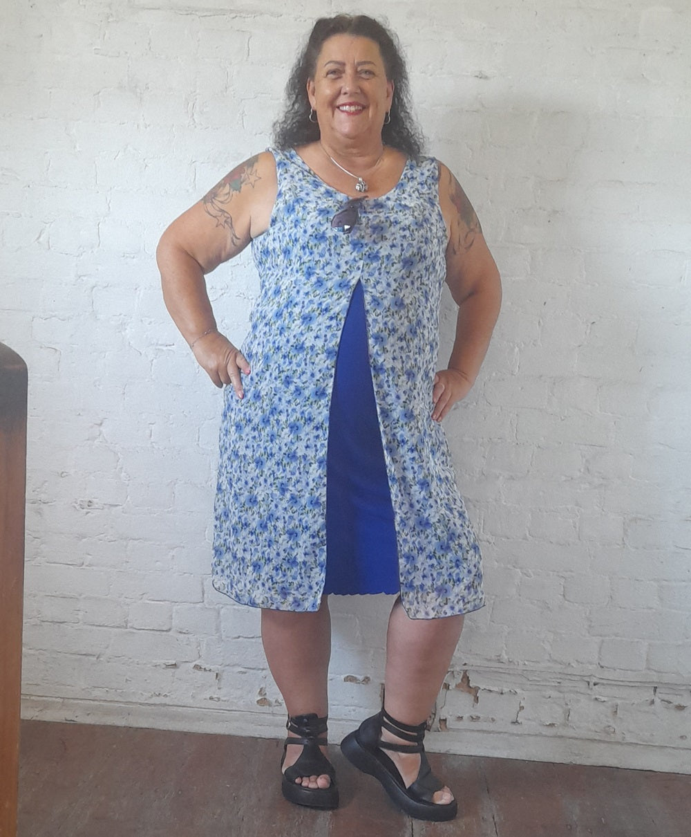 Blue sleeveless floral midi dress with a dark blue underskirt. 